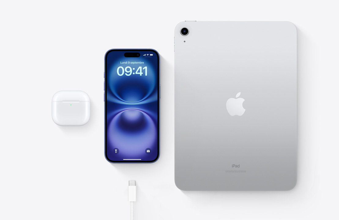 Vue en plongée des AirPods Pro, d’iPhone 16 et d’iPad, trois appareils dotés d’un connecteur USB-C qui peuvent être rechargés avec le même câble.