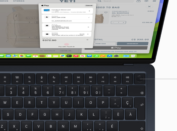 Vue en plongée d’un MacBook Air montrant le fonctionnement de Touch ID et du Magic Keyboard avec Apple Pay.