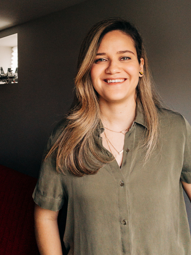 Photo portrait of Bianca, with big smile, looking at the reader.