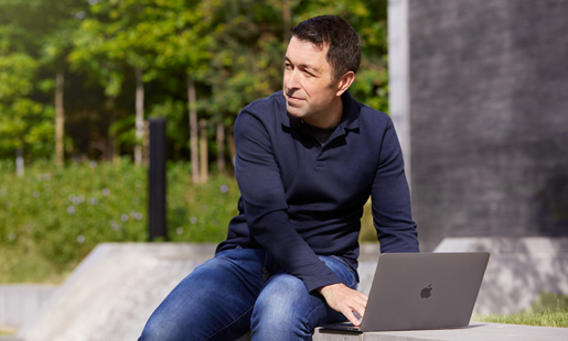 Rob sitting outside, working on his laptop.