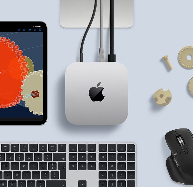 Top view of silver Mac mini in a desk setup with a black-and-silver wireless keyboard, a black wireless mouse, and an iPad