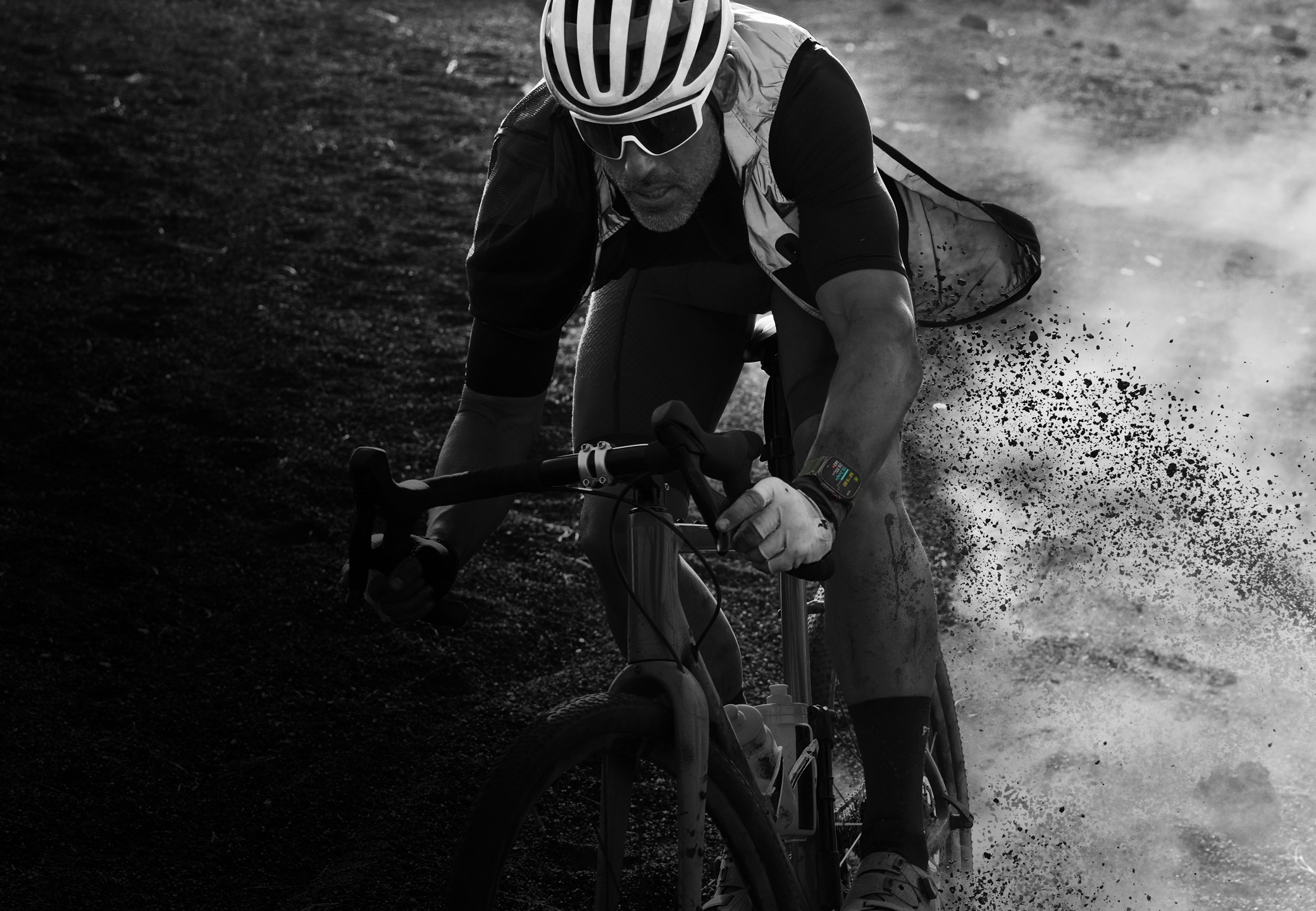 Una persona que lleva puesto un Apple Watch Ultra 2 desciende en bicicleta por un sendero de montaña.