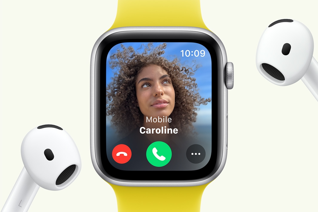 На Apple Watch SE відображається вхідний виклик, поруч розташовані навушники AirPods