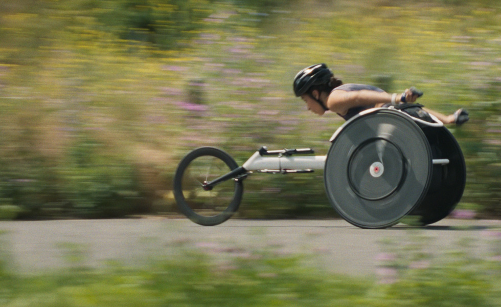 Une femme en train de faire une course en fauteuil de course.