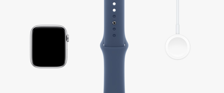 Colocados en fila: parte frontal del hardware de un Apple Watch SE, una correa deportiva blanco estelar y un cable de carga magnética con conector USB-C.