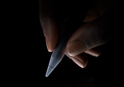 Una mano pronta a scrivere che tiene fra pollice e indice la parte inferiore di Apple Pencil Pro, poco sopra la punta.